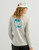 HUK Pursuit Graphic - Huk Circle Palm, a women's long sleeve performance shirt featuring a large graphic of a circular palm tree design with the brand name 'HUK' on the back.