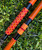 NICK'S CUSTOM RODS 2025 Fall Nick's Custom Rods - CTS 1205 Spinning fishing rod, orange and black designed fishing pole on green grass.