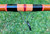 NICK'S CUSTOM RODS 2025 Fall Nick's Custom Rods - CTS 1205 Spinning, close-up of a fishing rod with colorful accents and a sturdy guide on a green grassy background.