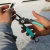TOADFISH Toadfish Inshore 8" Stainless Pliers - Elite Series, close-up of a person holding the fishing pliers with a beach background.