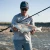 TOADFISH Toadfish Surf Combo, person holding a large fish with a fishing rod at the beach.