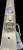 DEERFIELD FABRICATION Deerfield Open Face 2.0 Sand Spike, close-up view of the aluminum sand spike with a logo featuring an anchor and American flag design, attached to a metal surface.