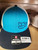 F&F Offset Embroidered Logo Hat, blue and beige trucker cap with embroidered text and logo, adjustable strap, and price tag.