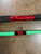 Full Send Rod Co. Custom CTS 1305 fishing rod, red and green sections with black accents and a fishing hook, on a concrete surface.