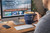 EVERYTHING BRANDED F&F Ceramic Coffee Mug, a blue ceramic mug with F&F Bait & Tackle logo held by a person on a wooden desk near a computer