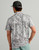 HUK Pursuit KC Printed Polo, rear view of a man wearing a grey camouflage patterned polo shirt and a black cap with a blue adjustable strap in a plain background