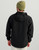 HUK Storm Jacket 2.0, back view of a man wearing a black waterproof jacket with a hood and elastic cuffs, paired with a green beanie and beige pants.