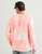 HUK Pursuit Mossy Oak Printed Long Sleeve Crew, a man's pink crewneck shirt with a Mossy Oak camouflage pattern and red text on the back.