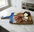Toadfish Wooden Coastal Serving Board, a handcrafted wooden cheese and charcuterie board with a blue ocean wave design on one side, featuring various cheeses, meats, crackers, grapes, and nuts on a marble kitchen counter.