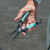 TOADFISH Toadfish Inshore Essentials Tool Kit, hand holding multi-functional fishing tool with salt-tough construction, X-TAC grips, spring loaded latch, carbine nippers, bottle opener, quick release carabiner, made from 420 stainless titanium coated.
