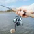 Toadfish Toadfish Stono Combo, a person holding a fishing rod with a reel and cork handle over a body of water on a clear day.