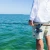TOADFISH Toadfish Stono Combo, fishing rod and reel set held by a person on a boat in the ocean.