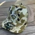 NICK'S CUSTOM RODS Nick's Custom Camo Hat, camouflage trucker hat with embroidered logo and mesh back on wooden surface.
