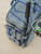 MUSTAD Mustad Game Time Backpack, a gray fishing backpack with fishing rod holder and multiple storage compartments on a concrete surface.