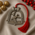 Pewter ornament with mallards and red tassel.