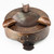 Copper ashtray with strapwork and rivet details.