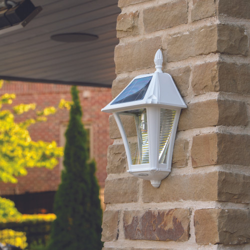 White solar wall amount carriage lanterns can be installed on any flat surface, including a brick wall, for a modern, clean look.