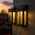 Black solar wall and deck lights have an ocean wave glass design that casts beautiful light at night.