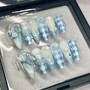 baby blues nail set featuring blue gingham, angel wings, pearls, and stars