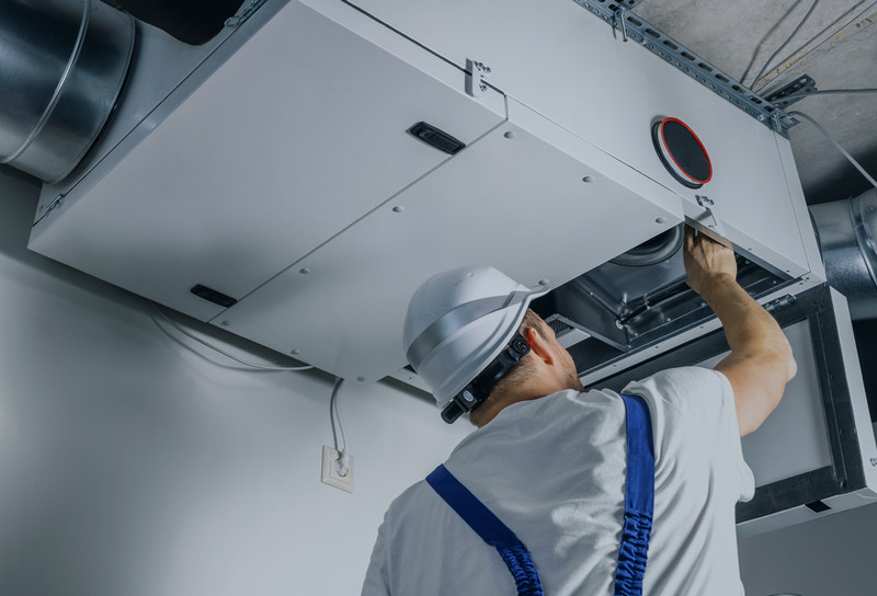 HVAC technician working on unit with access panel open