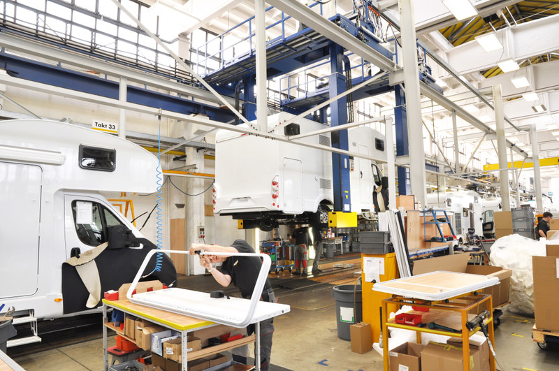 RV Manufacturing facility with workers assembled parts and RVs