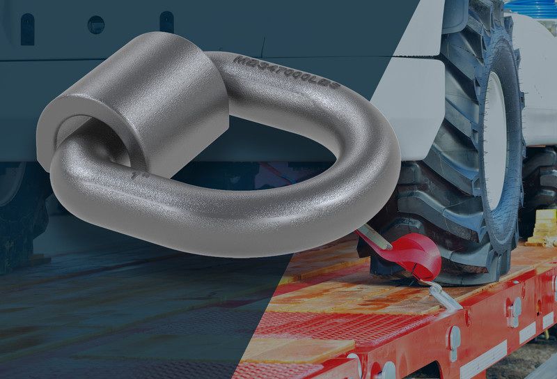 Image of d ring up close with a truck in the background with a vehicle tied down using a d ring