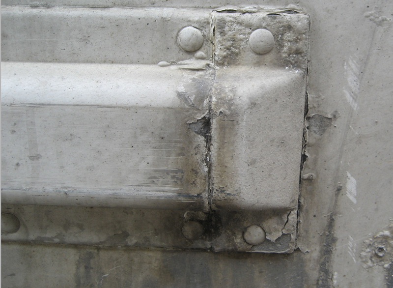 Corrosion on back end of trailer where moisture entered under fasteners and cause paint to bubble