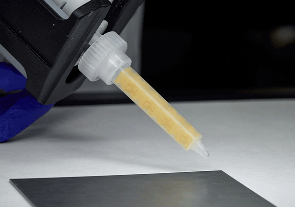 Person applying adhesive using applicator gun and ReMixer™ tip