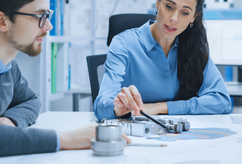 People meeting around table with product sample and drawings