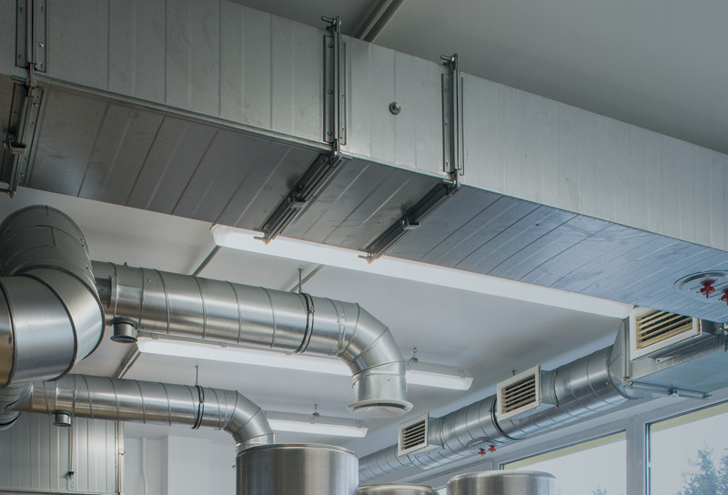 Ceiling duct work in industrial building showing fasteners holding unit in place