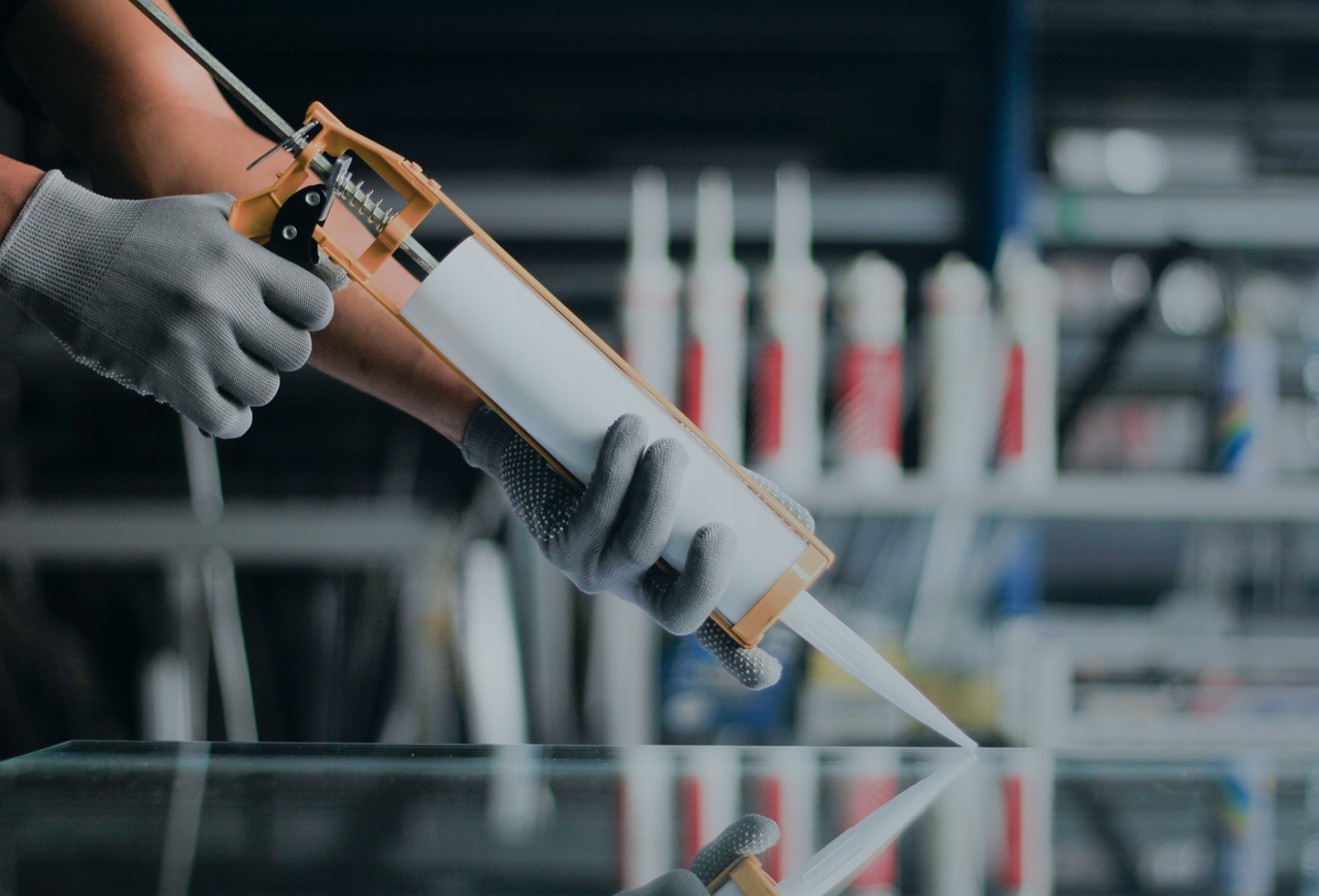 Person applying caulk with gloves on