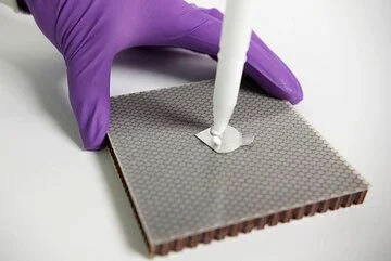 Close up of adhesive being applied to panel