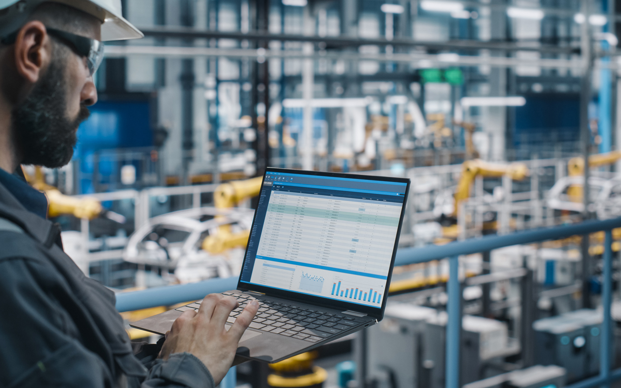 Engineer on computer in factory setting