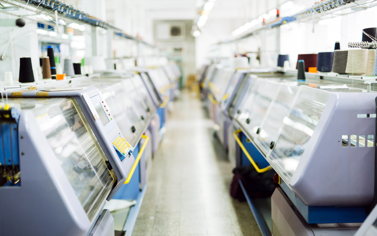 Row of machines in factory with windows and rubber trim to protect
