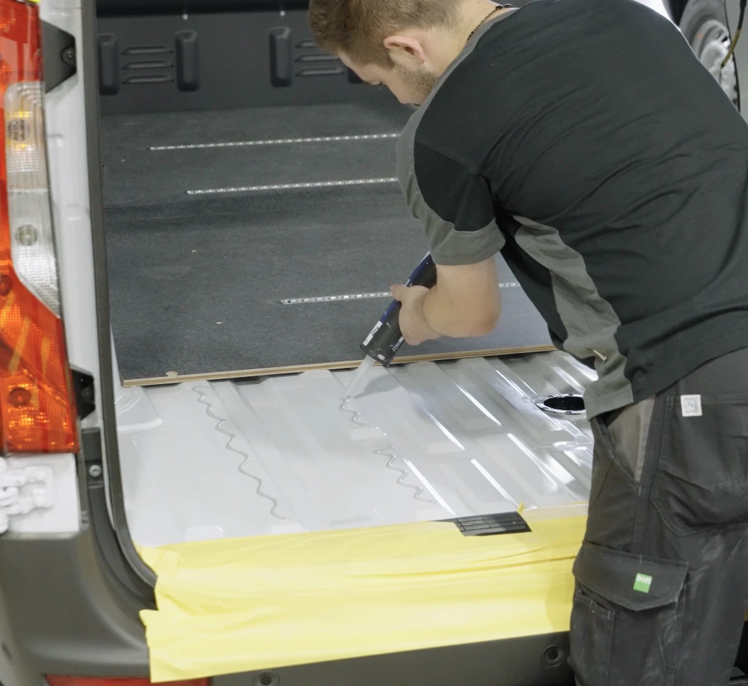 SABA adhesive being applied to the flooring on a vehicle interior