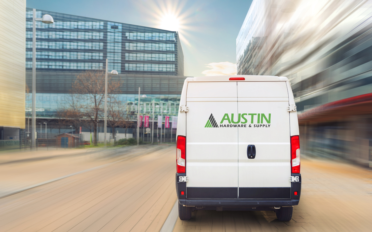 Delivery van with Austin Hardware logo driving through city