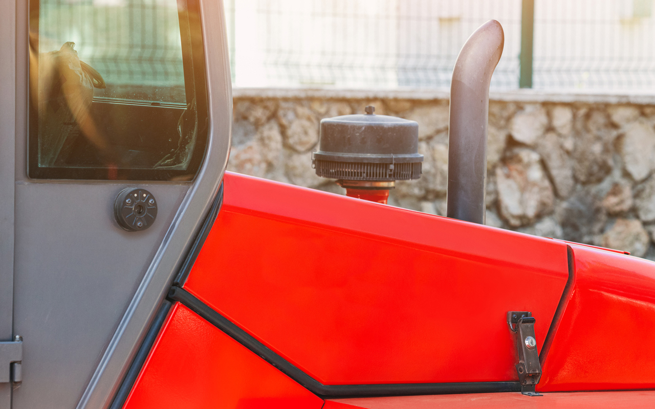 Side of tractor hood with toggle clamp locking hood