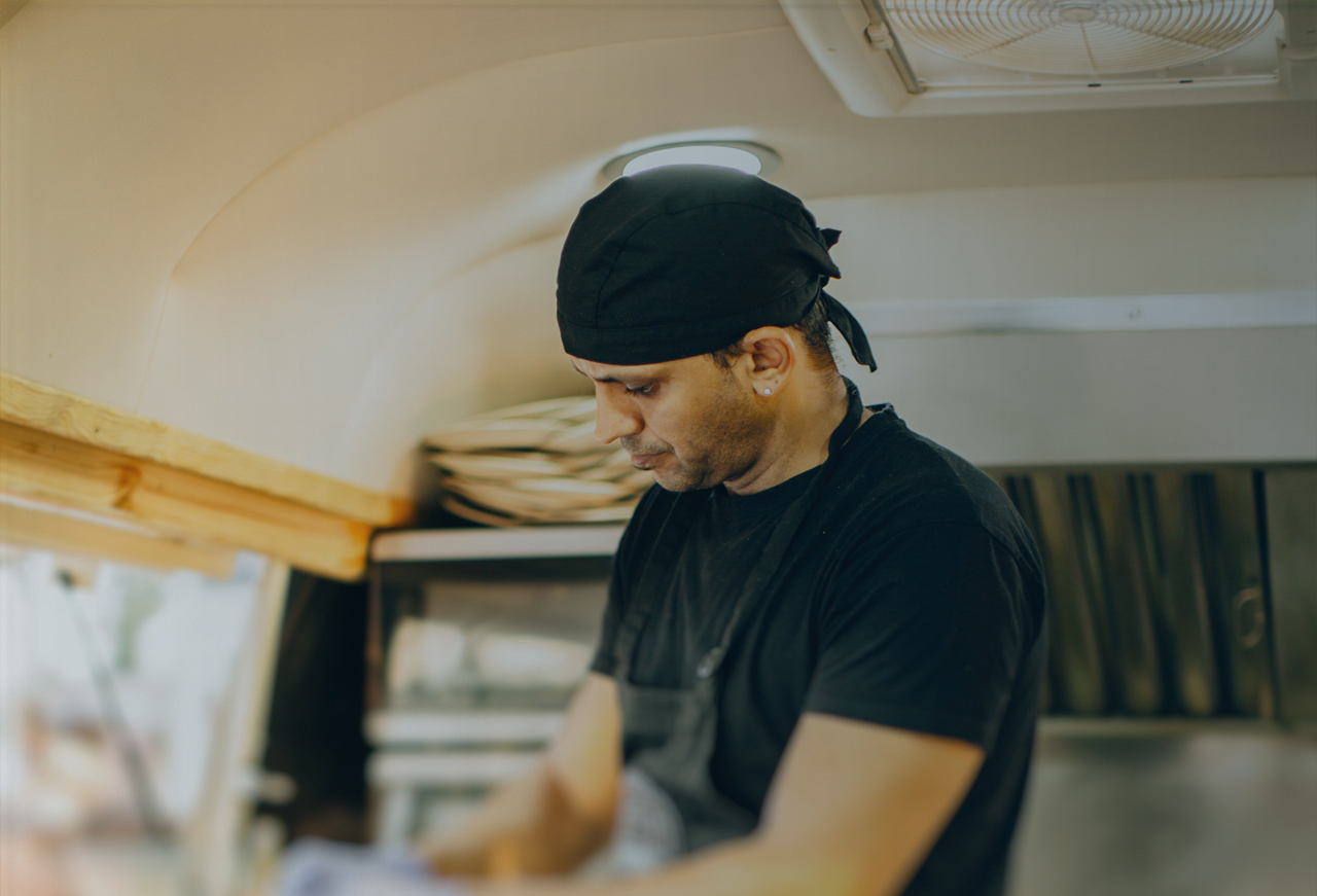Chef in food truck showing vent in the ceiling in background