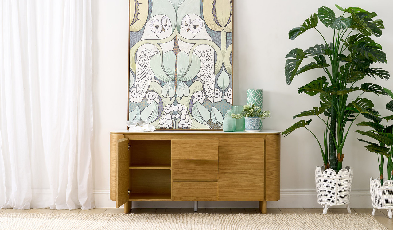 Cara buffet with matte white carrara-look ceramic top, natural oak finish, three soft-close drawers and two doors with internal shelf, 1600mm wide