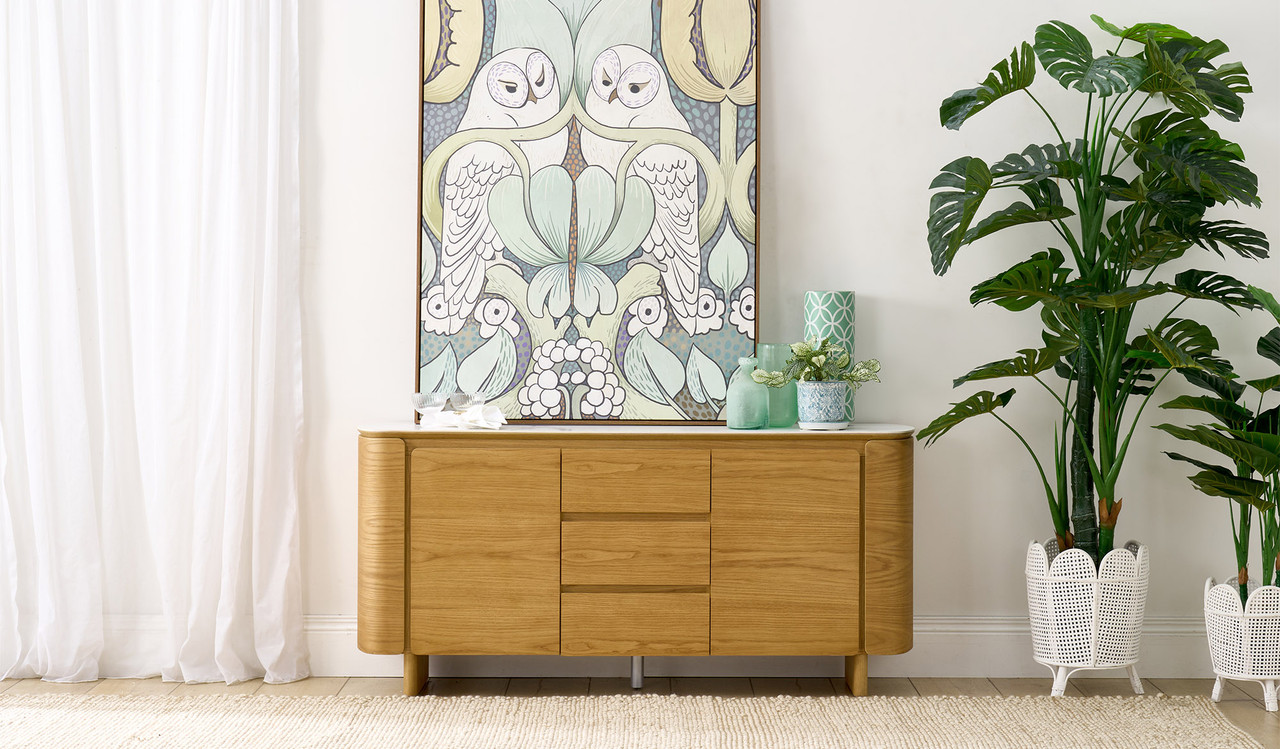 Cara buffet with matte white carrara-look ceramic top, natural oak finish, three soft-close drawers and two doors with internal shelf, 1600mm wide