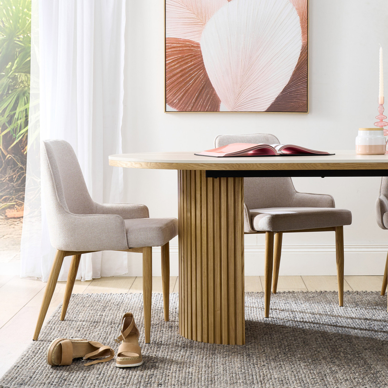 Eclipse dining table with travertine ceramic top, ash mountain grain detail, and half column slatted base in matte black or natural finish
