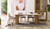 Eclipse dining table with travertine ceramic top, ash mountain grain detail, and half column slatted base in matte black or natural finish