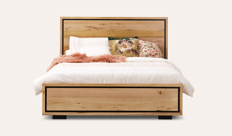 Eden bed in sustainable Australian messmate timber with natural knots, sleek edges, and black detailing, modern timber bed frame