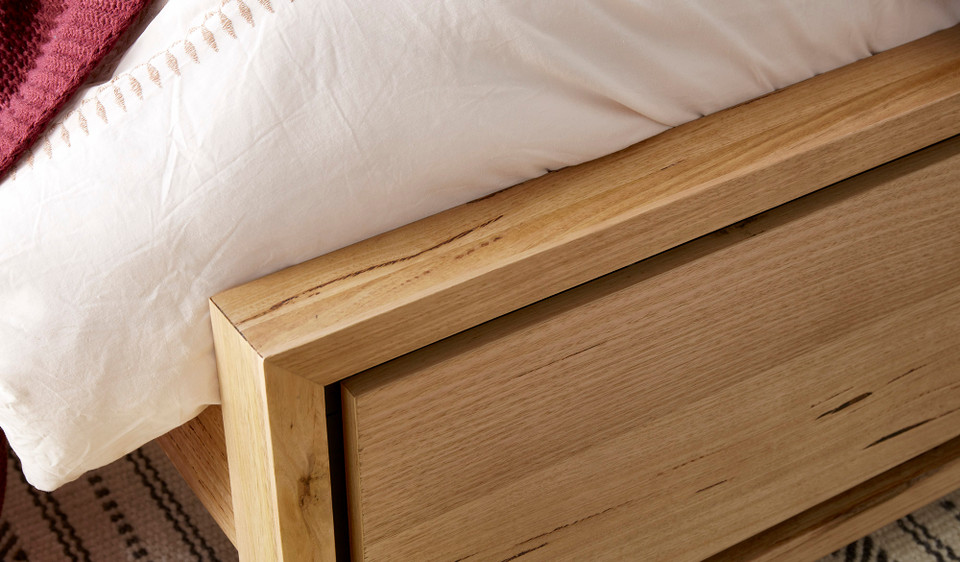 Eden bed in sustainable Australian messmate timber with natural knots, sleek edges, and black detailing, modern timber bed frame