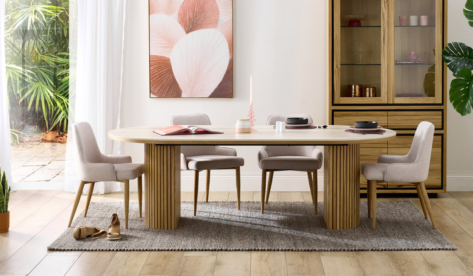 Eclipse dining table with travertine ceramic top, ash mountain grain detail, and half column slatted base in matte black or natural finish