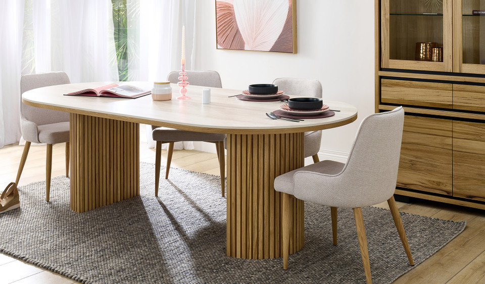 Eclipse dining table with travertine ceramic top, ash mountain grain detail, and half column slatted base in matte black or natural finish
