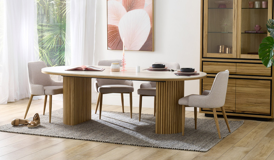 Eclipse dining table with travertine ceramic top, ash mountain grain detail, and half column slatted base in matte black or natural finish
