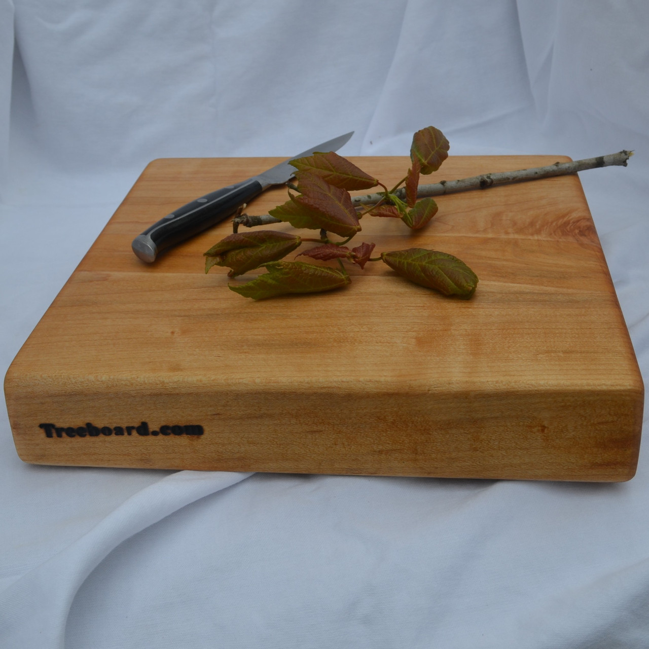 https://cdn11.bigcommerce.com/s-1vey7r6116/images/stencil/1280x1280/products/112/408/hard-maple-solid-cutting-board-by-Treeboard-medium-leaves-knife__72797.1669344747.jpg?c=1