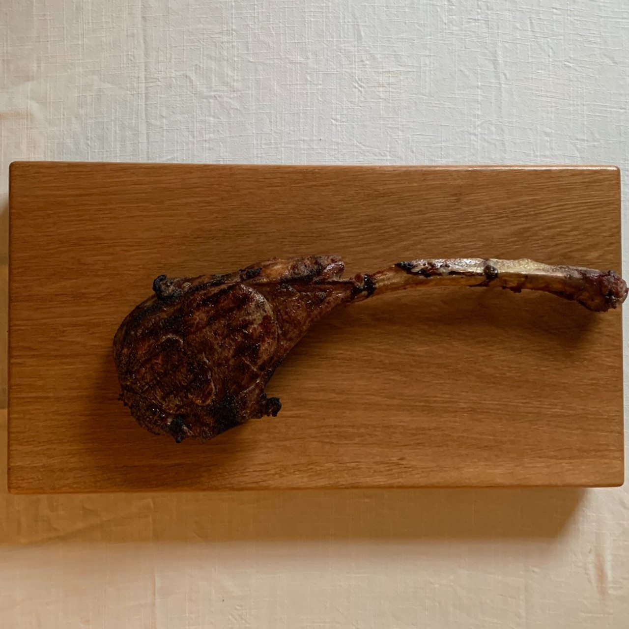https://cdn11.bigcommerce.com/s-1vey7r6116/images/stencil/1280x1280/products/124/513/large-white-oak-cutting-board-by-Treeboard-tomahawk-steak-above-1280__45402.1686530952.jpg?c=1