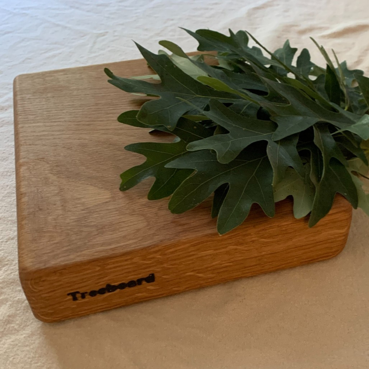 https://cdn11.bigcommerce.com/s-1vey7r6116/images/stencil/1280x1280/products/130/473/small-white-oak-cutting-board-by-Treeboard-leaves__68069.1669344772.jpg?c=1